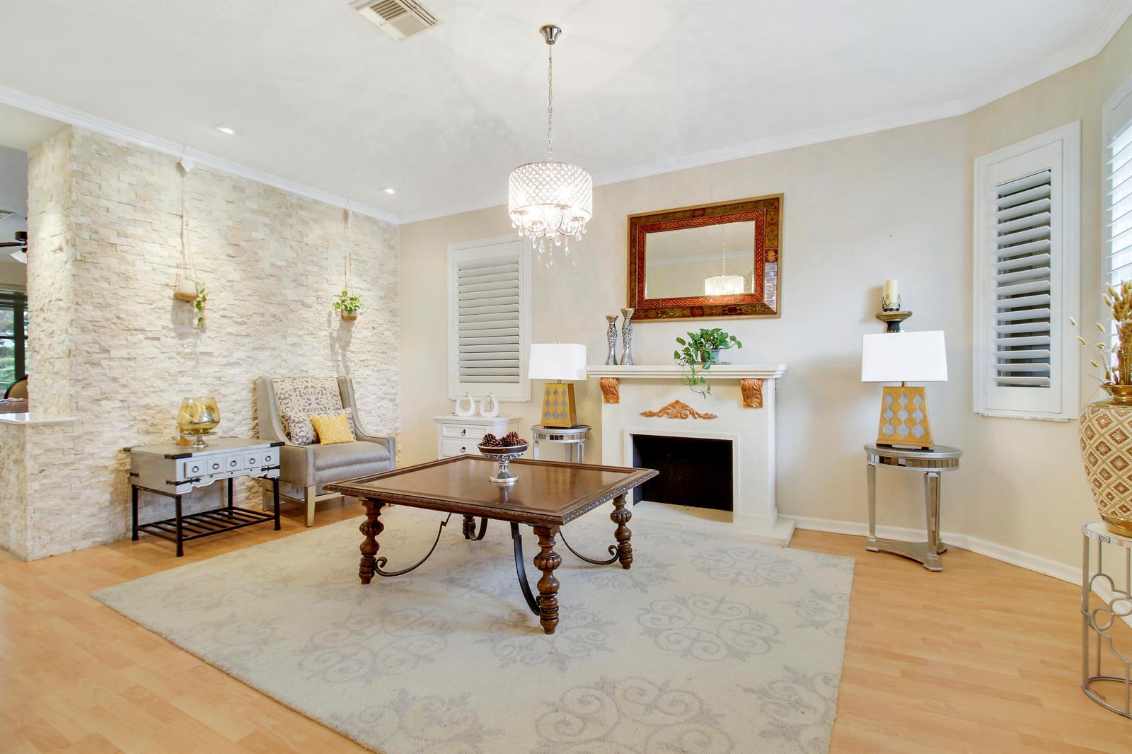 A living room features a stone accent wall, a fireplace, a chandelier, and hardwood floors — 1448 Artimino Lane, Boynton Beach FL 33436, BOYNTON BEACH, FL