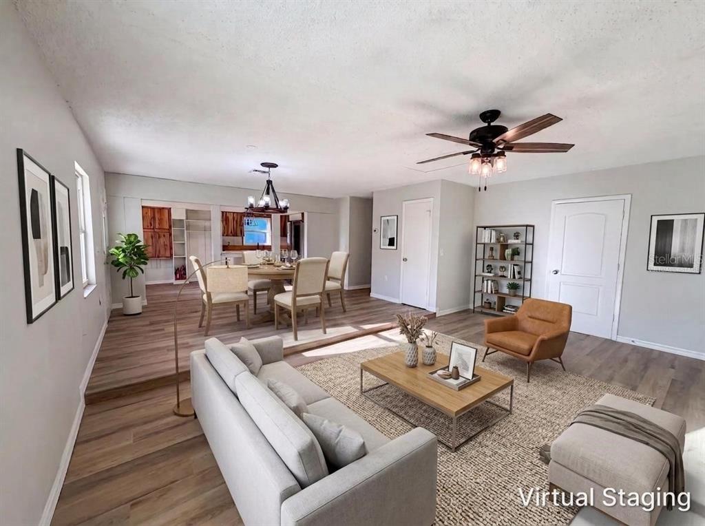 A living room and dining area with wood-look flooring, a ceiling fan, and virtual staging — 2230 SPRING HOLLOW DRIVE, ORANGE CITY, FL