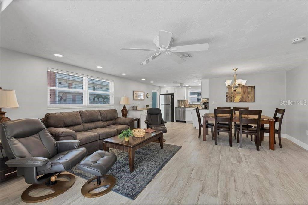 An open-concept living and dining area features light wood-look flooring and a ceiling fan — 6154 MIDNIGHT PASS ROAD UNIT C18, SARASOTA, FL