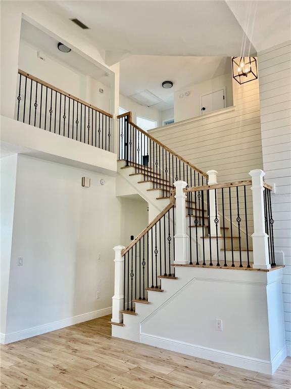 An interior view shows a staircase with black metal railings and wood handrails in a foyer — 13261 ROYAL GEORGE AVENUE, ODESSA, FL