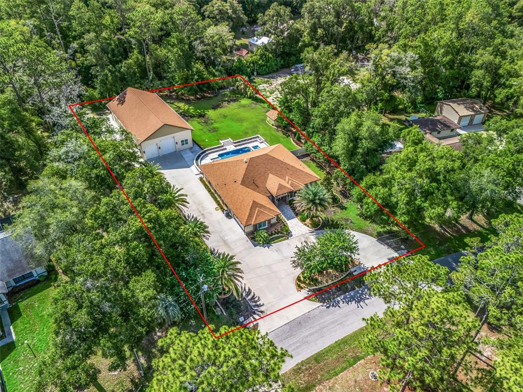 An aerial view shows a house with a pool and a detached garage on a lot — 10170 SW 202ND CIRCLE, DUNNELLON, FL