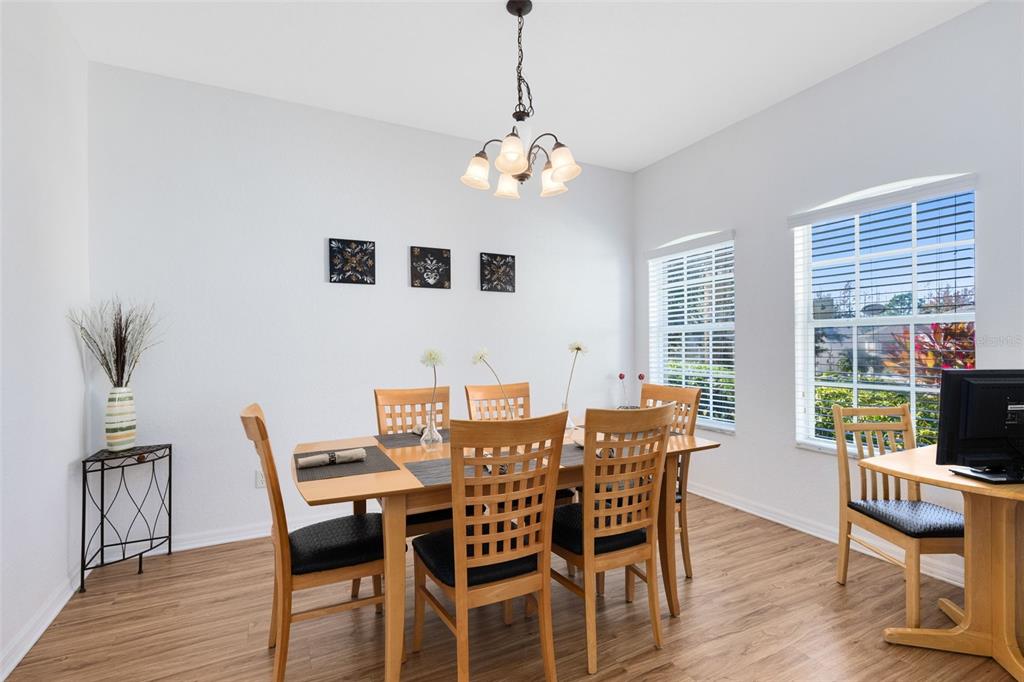 A dining room with light wood floors, a wooden table and chairs, and a chandelier — 142 BIRKDALE STREET, DAVENPORT, FL