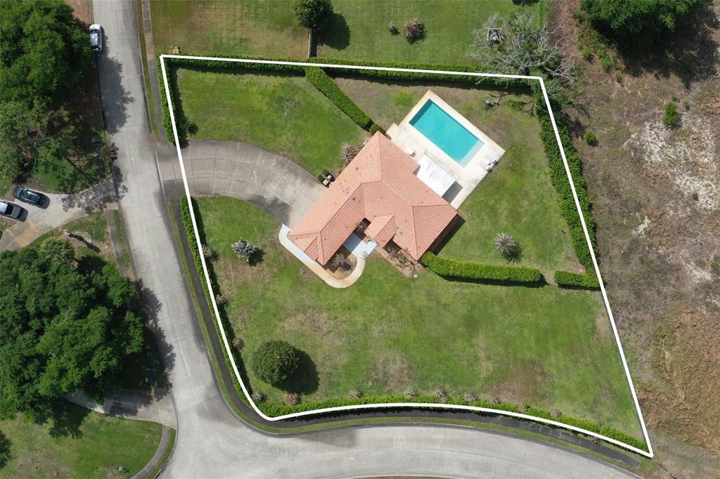 An aerial view shows a house with a pool and a large yard outlined in white — 12623 LAKE DENISE BOULEVARD, CLERMONT, FL
