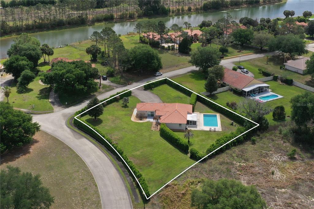 An aerial view shows a single-story house with a tile roof, pool, and large yard — 12623 LAKE DENISE BOULEVARD, CLERMONT, FL