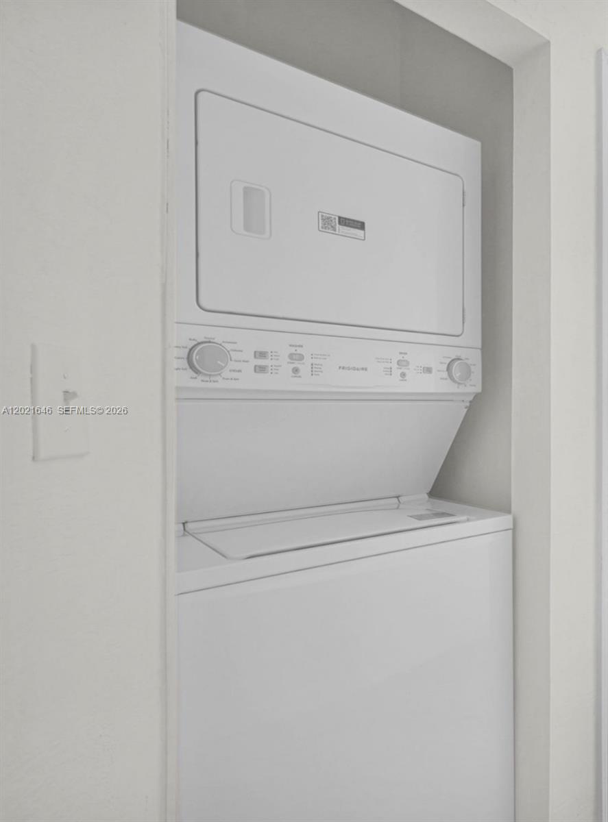 A white Frigidaire stacked washer and dryer unit is installed in a recessed wall alcove — 151 NW 42nd St # 1, Miami FL 33127, MIAMI, FL