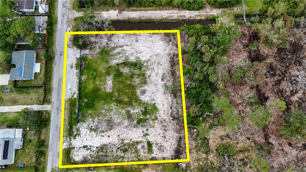 An aerial view shows a rectangular, cleared vacant lot outlined in yellow next to a road — 6644 OELSNER STREET, NEW PORT RICHEY, FL