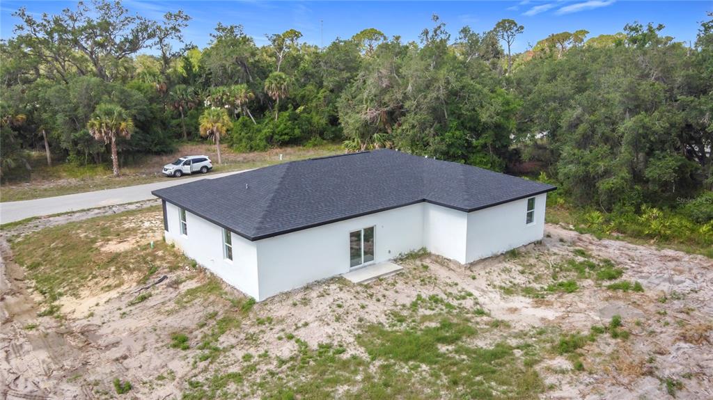 An aerial view of a white, single-story house with a dark roof and unfinished landscaping — 16134 LIBOURN AVENUE, PORT CHARLOTTE, FL