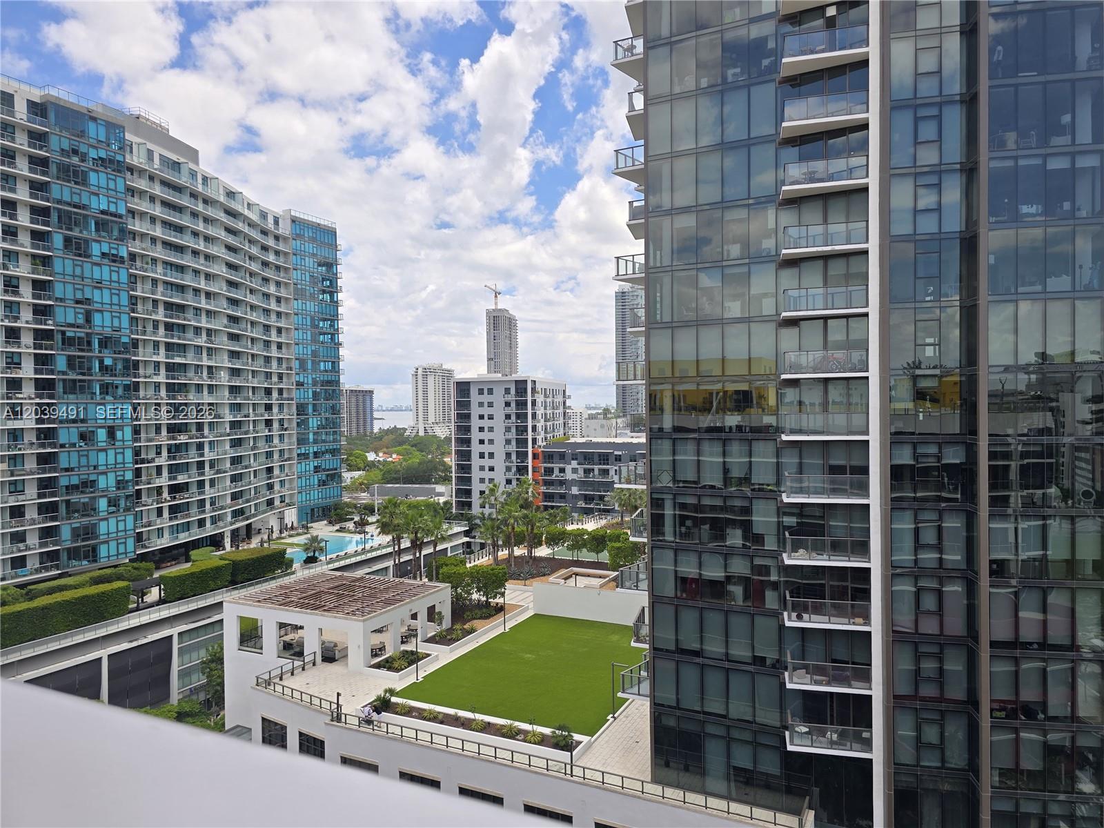 An elevated view of a courtyard between two modern high-rise apartment buildings — 90 NE 32ND ST # 305, Miami FL 33137, MIAMI, FL