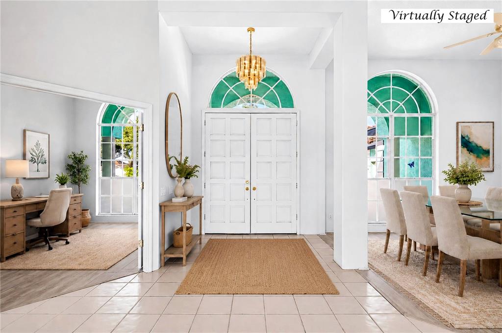 A bright entryway features white double doors, a gold chandelier, and tile flooring — 8911 RIVERLACHEN WAY, RIVERVIEW, FL