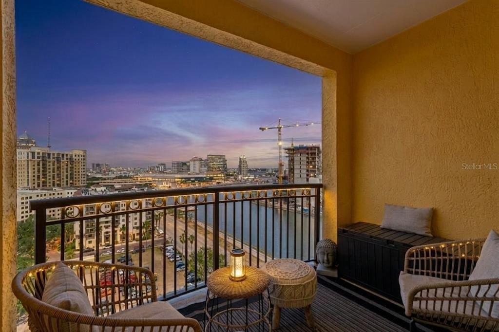 A balcony with wicker chairs and a table overlooks a city skyline and a canal — 345 BAYSHORE BOULEVARD UNIT 1510, TAMPA, FL