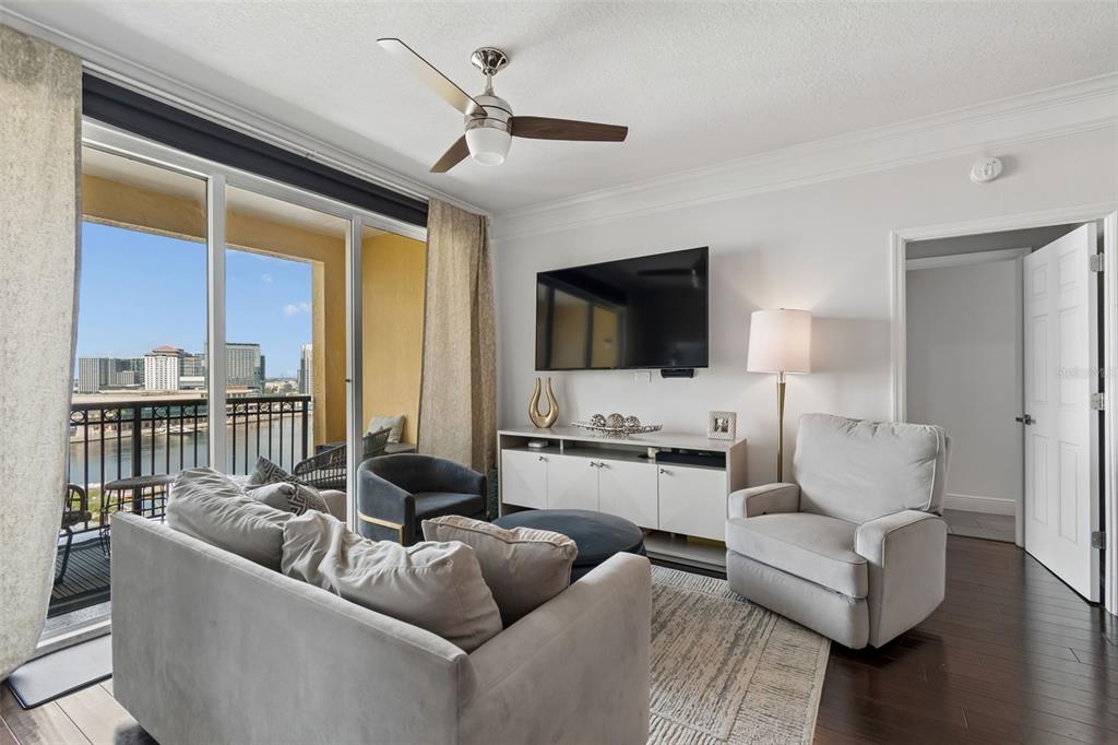 A living room features a sofa, armchair, media console, and a balcony overlooking a city — 345 BAYSHORE BOULEVARD UNIT 1510, TAMPA, FL