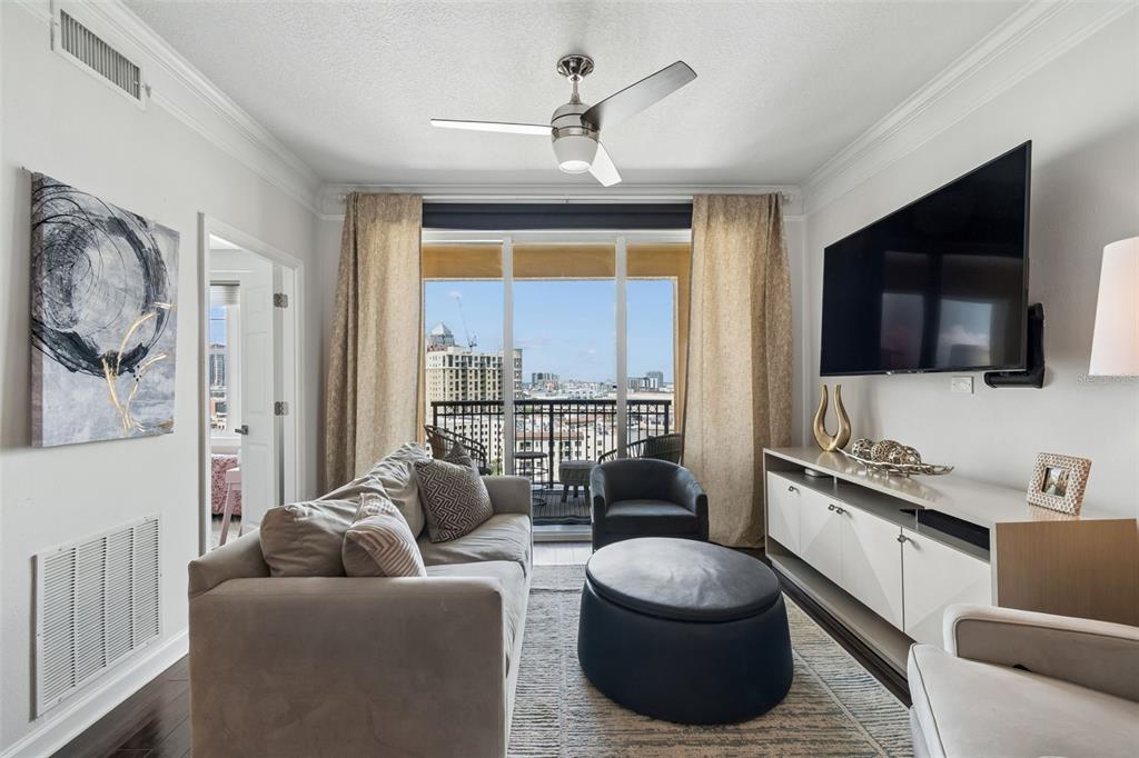A living room features a sofa, ottoman, television, and a balcony with a city view — 345 BAYSHORE BOULEVARD UNIT 1510, TAMPA, FL