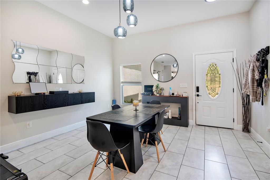 A dining room features a black table, matching chairs, a floating shelf, and a mirror — 1775 19TH STREET, ORANGE CITY, FL