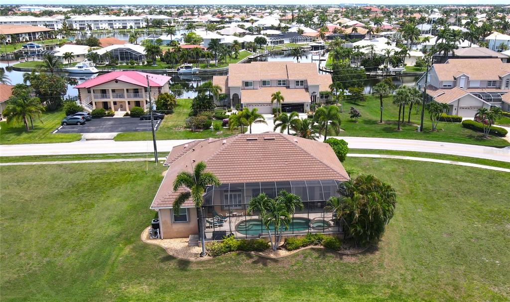 An aerial view shows a house with a screened-in pool and a brown tile roof — 3801 BAL HARBOR BOULEVARD, PUNTA GORDA, FL