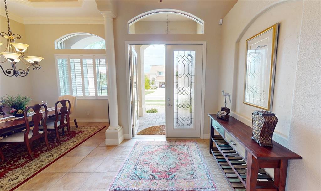 An entryway with a glass-paneled door, tile flooring, a console table, and a dining area — 3801 BAL HARBOR BOULEVARD, PUNTA GORDA, FL