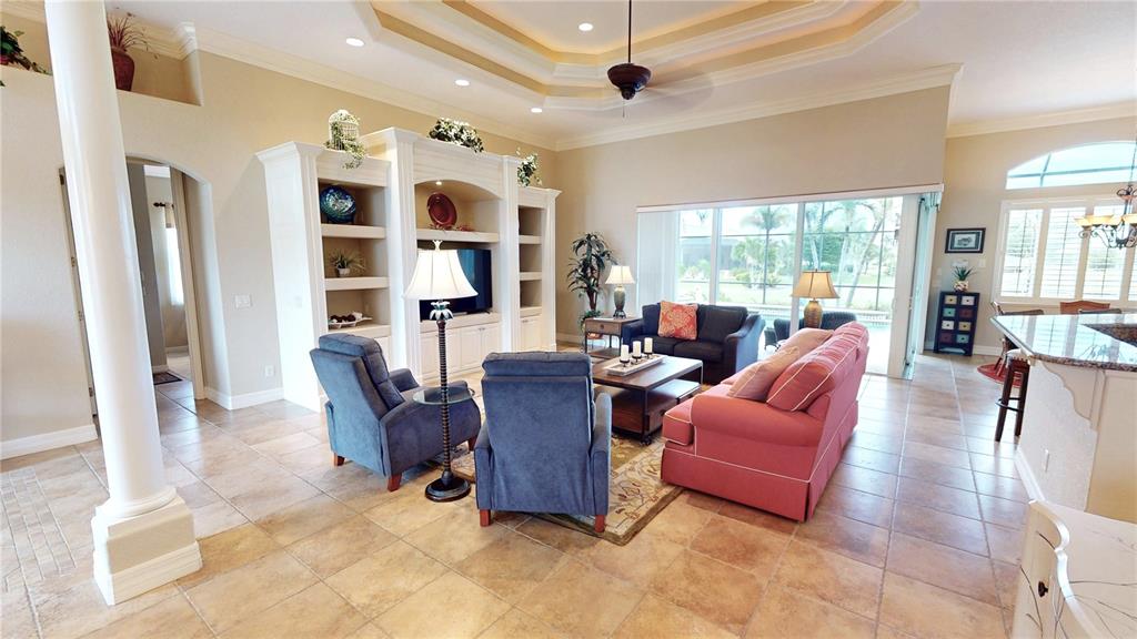 A living room features tile floors, a coffered ceiling, built-in shelving, and a sliding glass door — 3801 BAL HARBOR BOULEVARD, PUNTA GORDA, FL