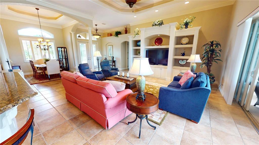 A living room features tile floors, a built-in entertainment center, and a coral-colored sofa — 3801 BAL HARBOR BOULEVARD, PUNTA GORDA, FL
