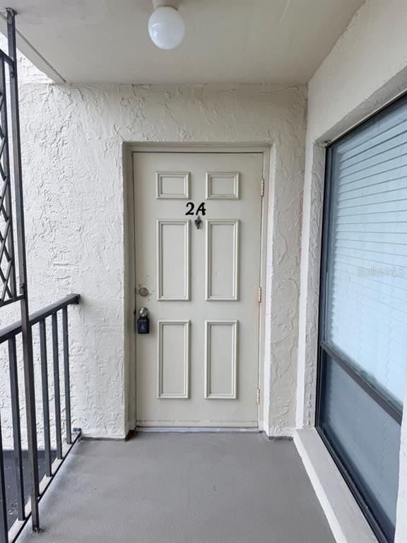 A beige exterior door marked with the number 2A sits on a covered balcony — 3300 COVE CAY DRIVE UNIT 2A, CLEARWATER, FL