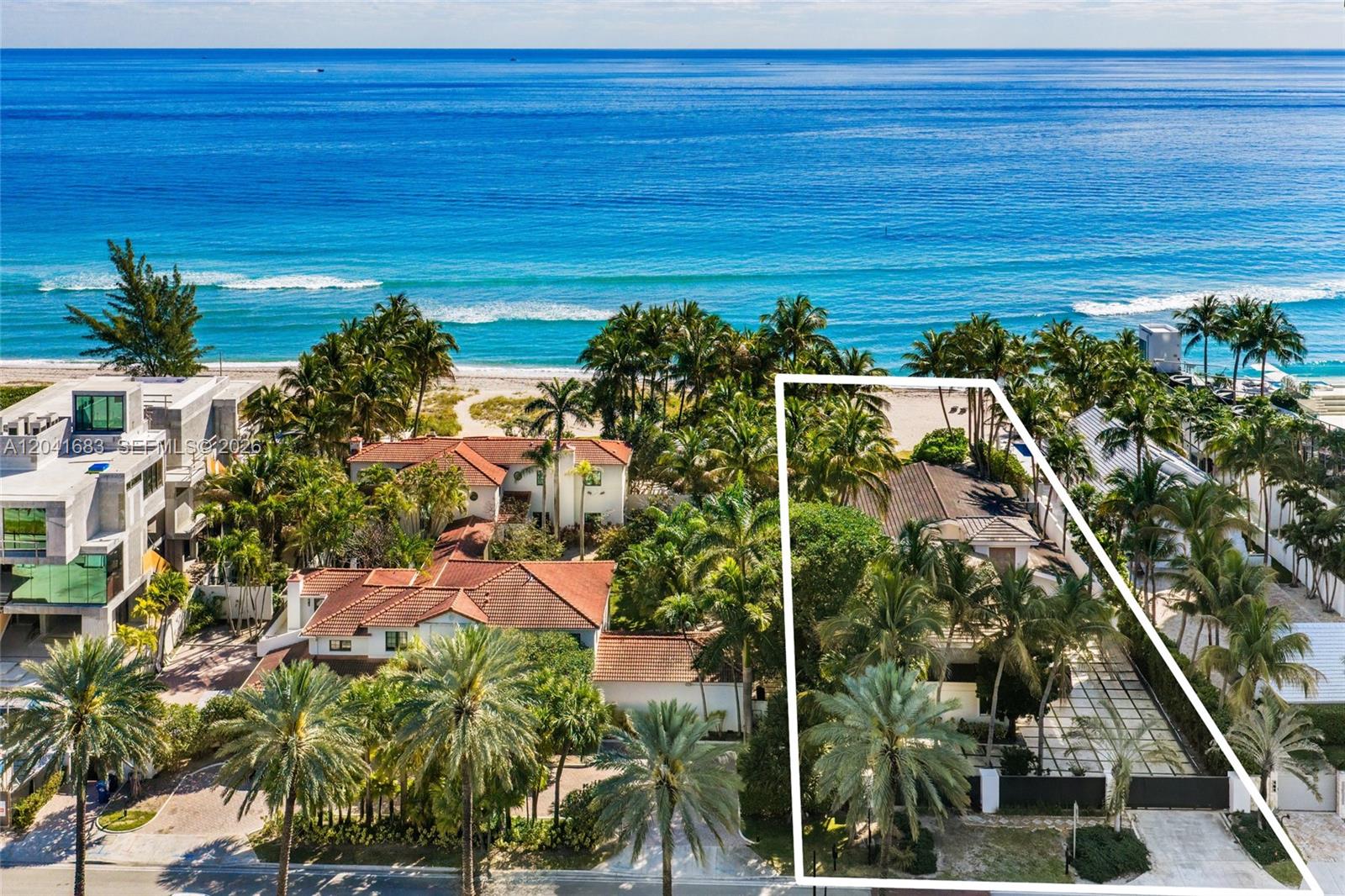 An aerial view shows a beachfront property with a house, palm trees, and a driveway — 105 Ocean Blvd, Golden Beach FL 33160, GOLDEN BEACH, FL
