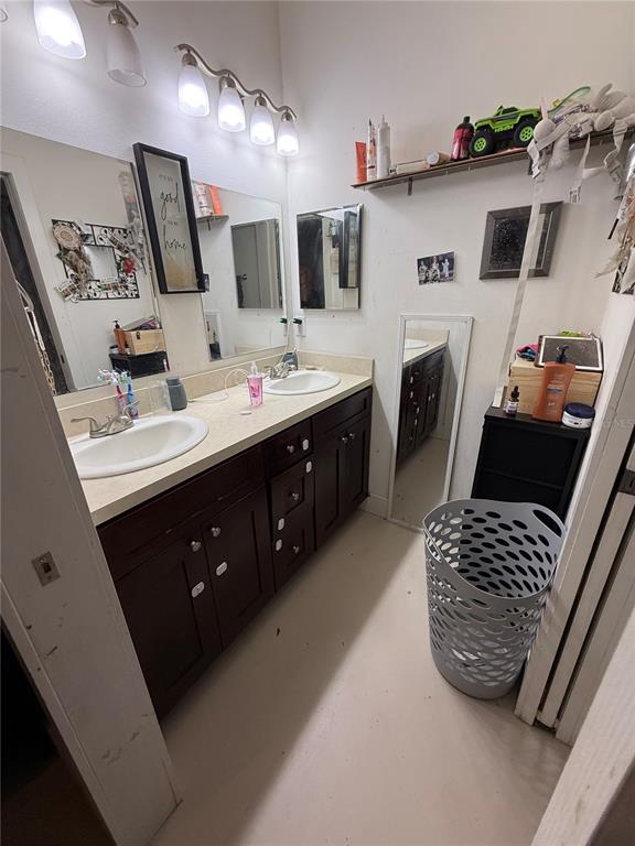 A bathroom features a double vanity with dark cabinets, a white countertop, and a laundry basket — 727 NW 4TH AVENUE, GAINESVILLE, FL