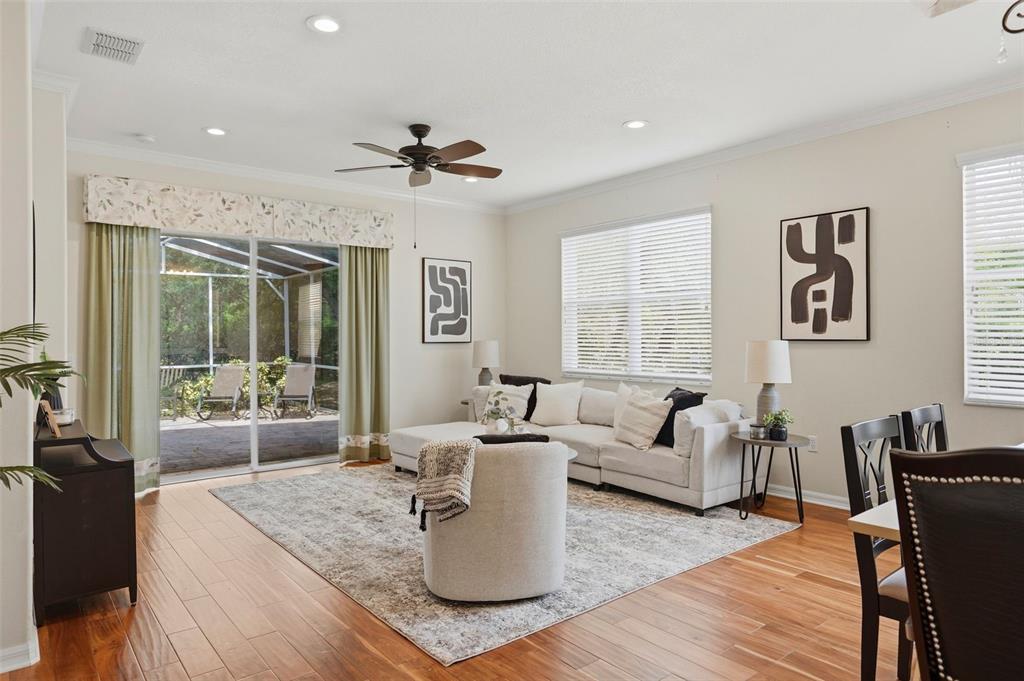 A living room with hardwood floors, a sectional sofa, and a sliding glass door — 8005 SHADDOCK PLACE, LAND O LAKES, FL