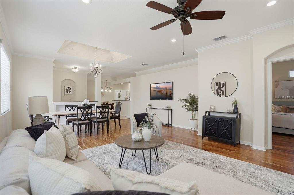 A living room with hardwood floors, a ceiling fan, and an adjacent dining area — 8005 SHADDOCK PLACE, LAND O LAKES, FL
