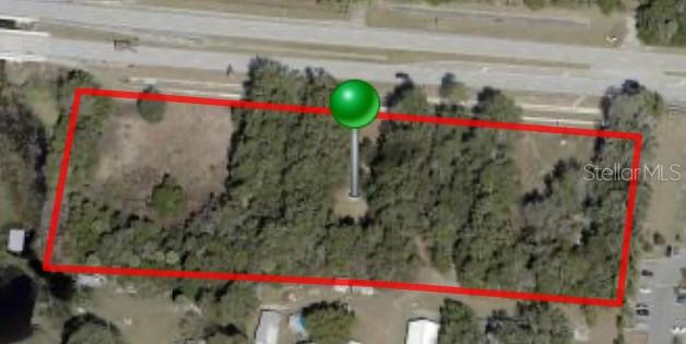 An aerial view shows a rectangular plot of land outlined in red with a location pin — 214 W INTERNATIONAL SPEEDWAY BOULEVARD, DELAND, FL