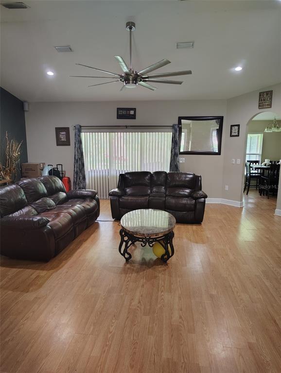 A living room features two brown leather sofas, a glass-topped coffee table, and wood flooring — 3226 WHEELER COURT, DOVER, FL