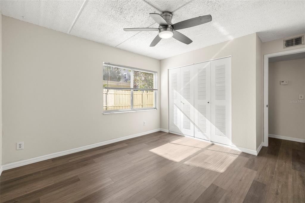 A kitchen features white upper cabinets, blue lower cabinets, a stainless refrigerator, and subway tile — 3206 W AZEELE STREET UNIT 128, TAMPA, FL