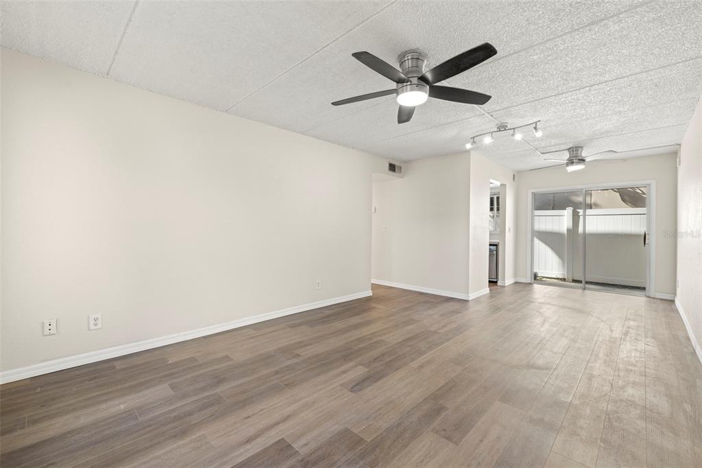 A kitchen features gray lower cabinets, white upper cabinets, white countertops, and a subway tile backsplash — 3206 W AZEELE STREET UNIT 128, TAMPA, FL