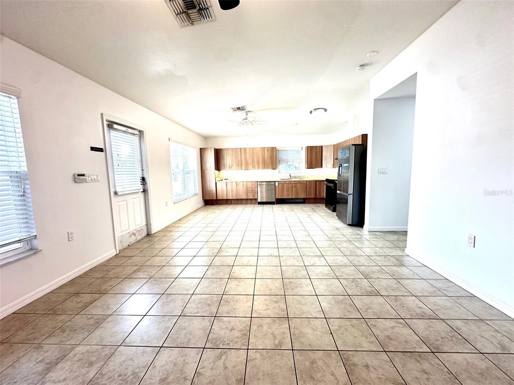 A kitchen with wood cabinets, stainless steel appliances, and tile flooring in an open room — 1121 DR MARTIN LUTHER KING JR STREET S, ST PETERSBURG, FL