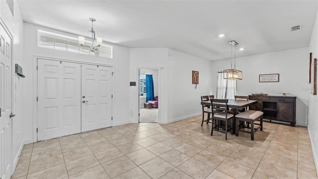 A tiled entryway leads to a dining area with a wooden table and sideboard — 4129 TIMBER VALLEY WAY, LAKELAND, FL