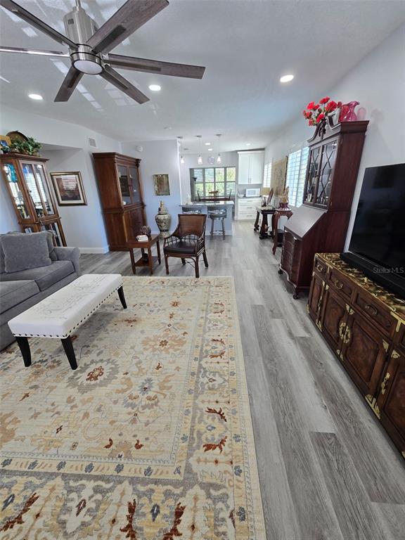 A living room with gray flooring, a patterned area rug, and traditional wooden furniture — 2430 FLORENTINE WAY UNIT 40, CLEARWATER, FL