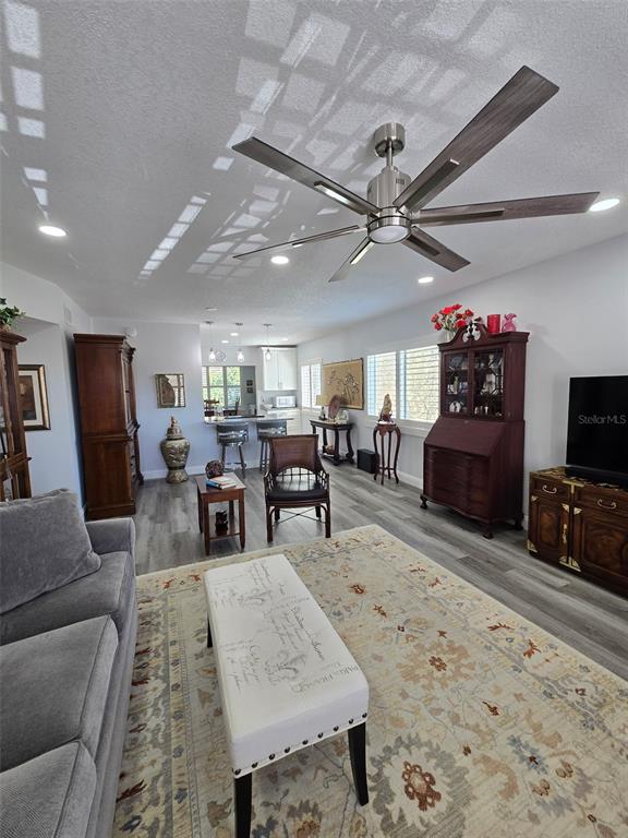 A living room with gray flooring, a ceiling fan, and a patterned area rug — 2430 FLORENTINE WAY UNIT 40, CLEARWATER, FL