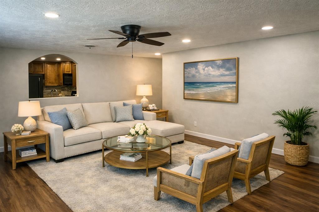 A living room features a beige sectional sofa, two wooden armchairs, and a round coffee table — 855 STEWART STREET, ENGLEWOOD, FL