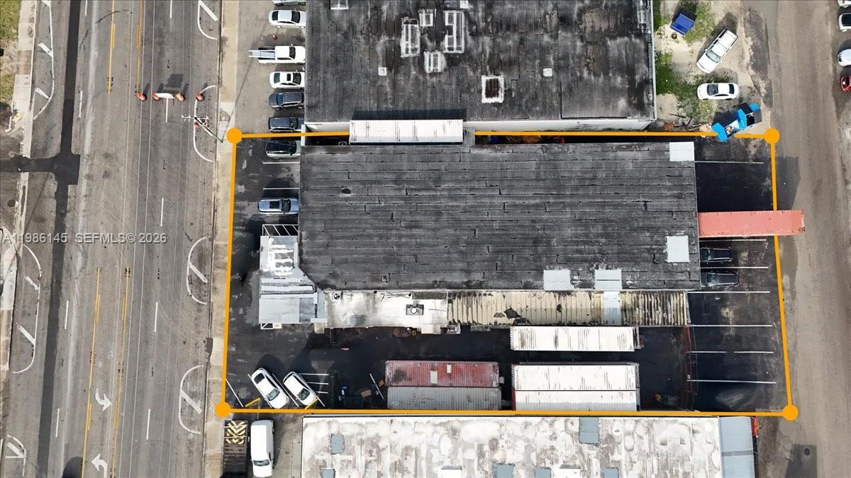 An aerial view shows a commercial building with a parking lot and shipping containers — 3595 NW 54th St, Hialeah FL 33142, HIALEAH, FL