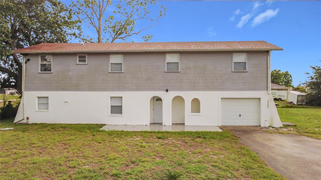 A two-story house with gray horizontal siding on top and white stucco on the bottom — 3303 6TH STREET SW, LEHIGH ACRES, FL