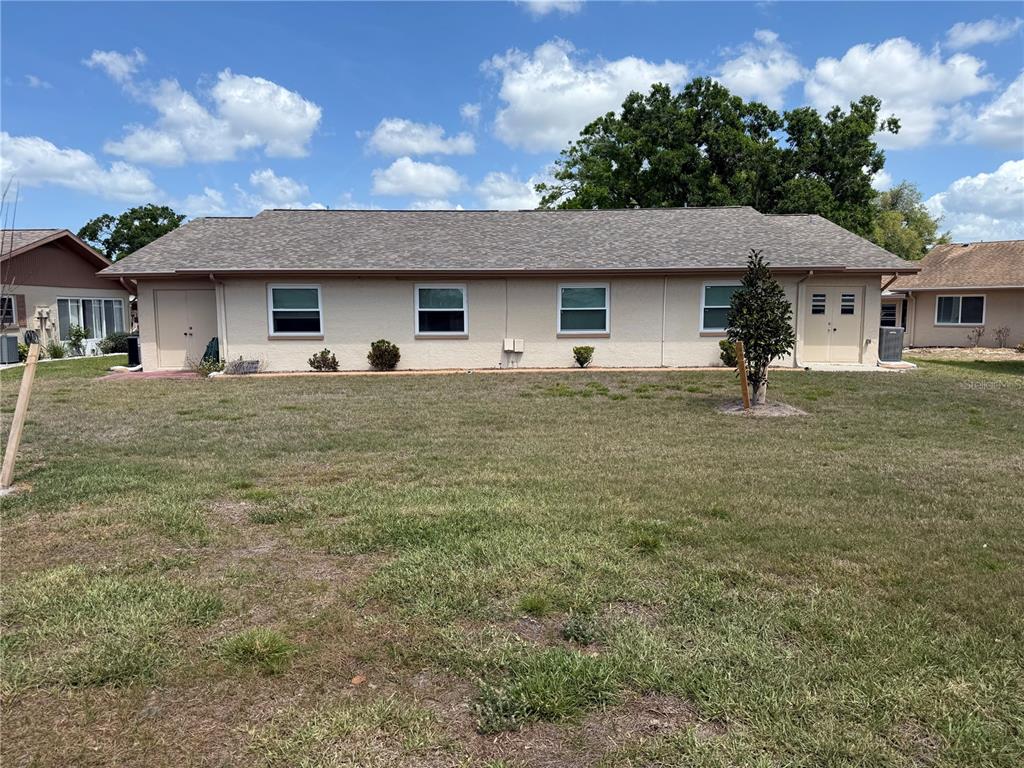 A single-story building with a light-colored stucco exterior and a shingled roof — 110-112 GLOUCESTER BOULEVARD, SUN CITY CENTER, FL