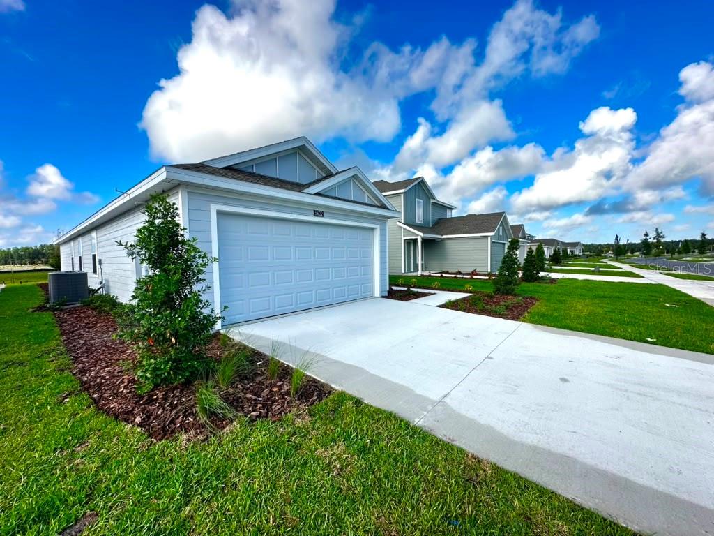 A light blue single-story house with a two-car garage and a concrete driveway — 5602 MORANT BAY PATH, KISSIMMEE, FL