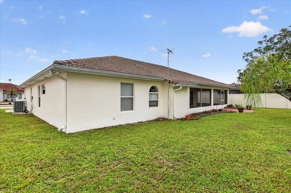 The exterior of a single-story house with a tan stucco finish and a tiled roof — 28 PRINCETON LANE, PALM COAST, FL