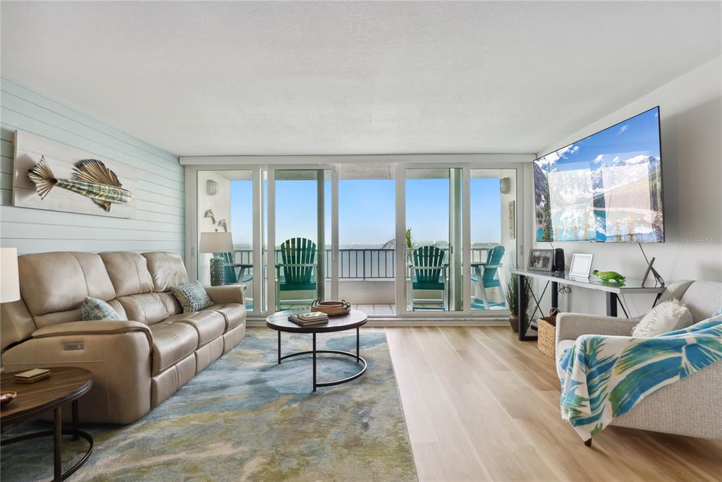 A living room features a beige sofa, a round coffee table, and a balcony view — 5279 ISLA KEY BOULEVARD S UNIT 212, ST PETERSBURG, FL