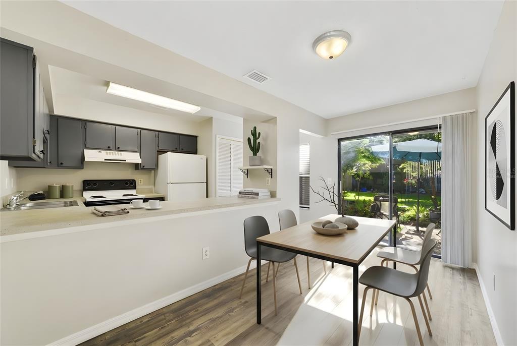 A kitchen with dark cabinets and a dining area featuring a sliding glass door — 605 CASA PARK COURT UNIT H, WINTER SPRINGS, FL