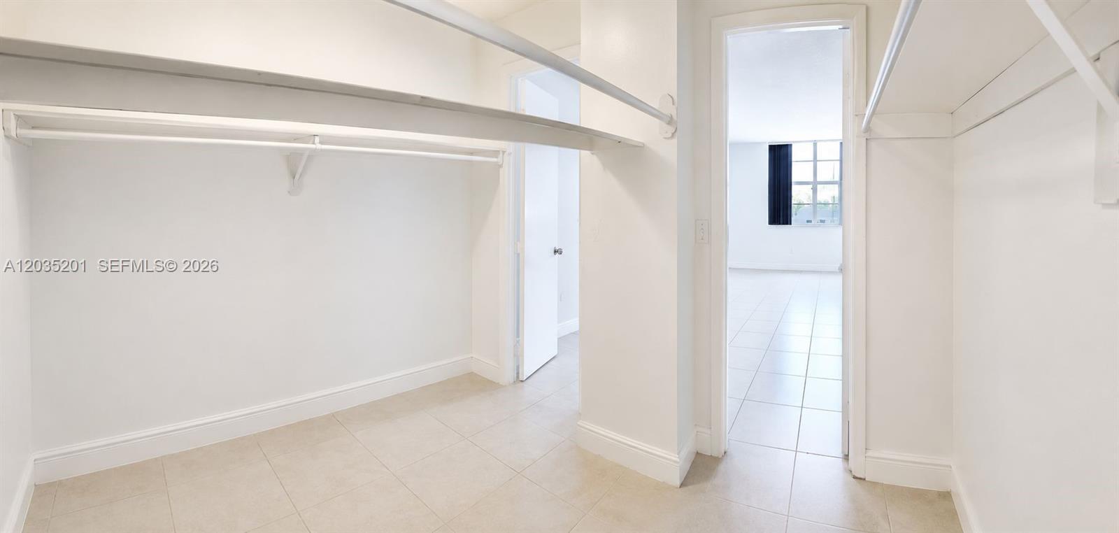 A bathroom features a white bathtub with marble-look tile walls, a toilet, and a vanity — 484 NW 165th St Rd # 109, Miami FL 33169, MIAMI, FL