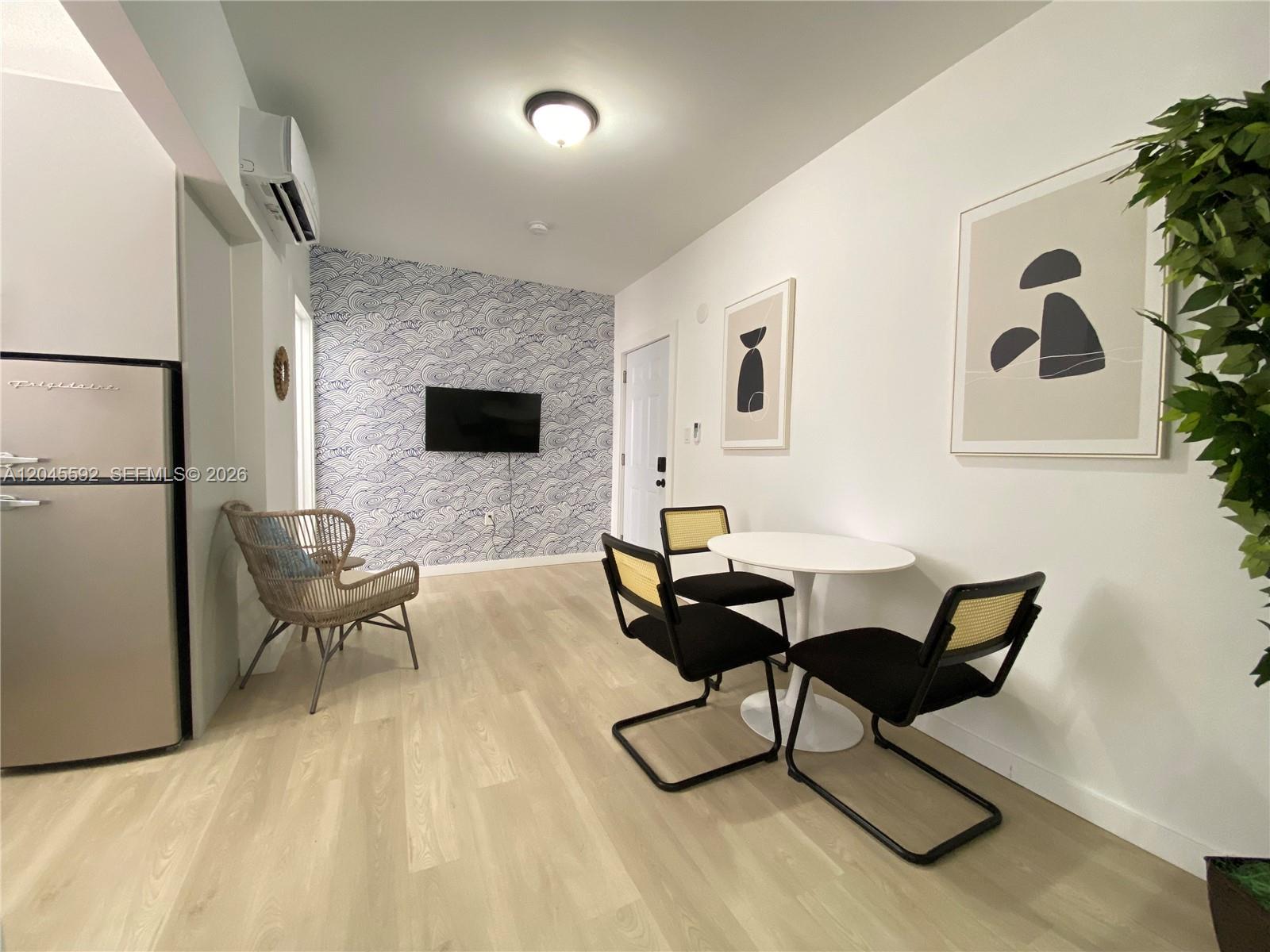 A small room features a patterned accent wall, a dining set, and a refrigerator — 1553 SW 7th St # 15, Miami FL 33135, MIAMI, FL