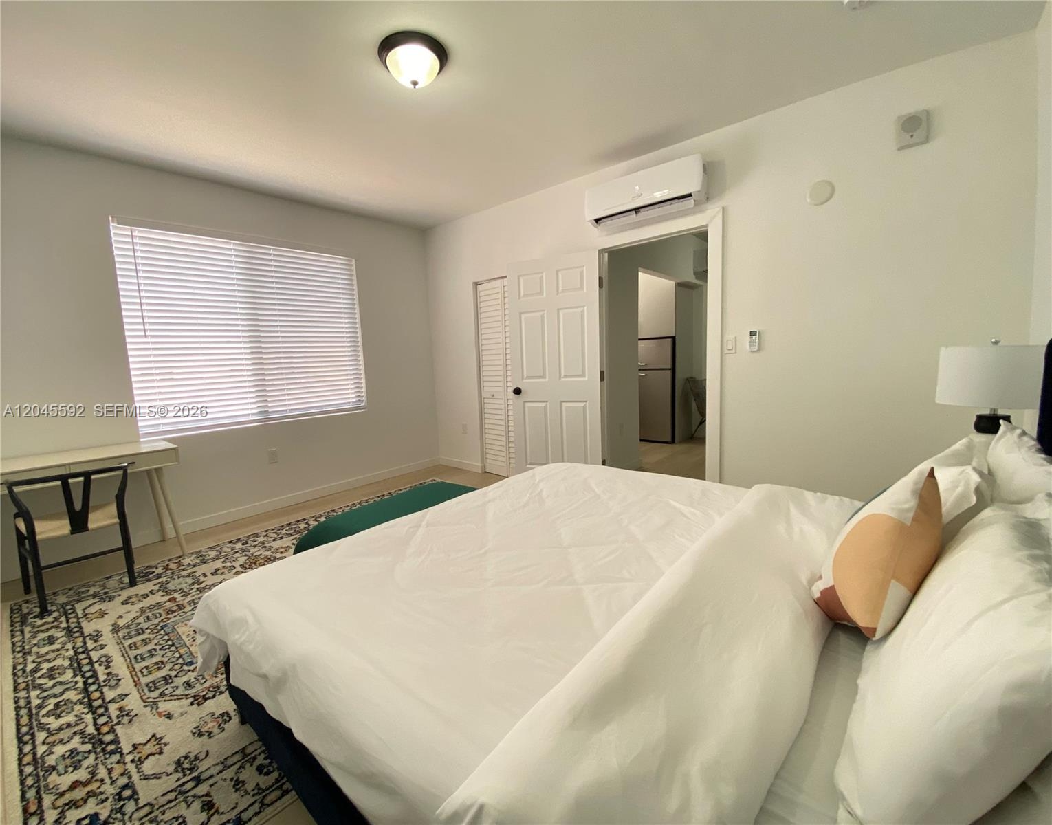 A bedroom features a bed, a desk, a patterned rug, and a doorway to another room — 1553 SW 7th St # 15, Miami FL 33135, MIAMI, FL