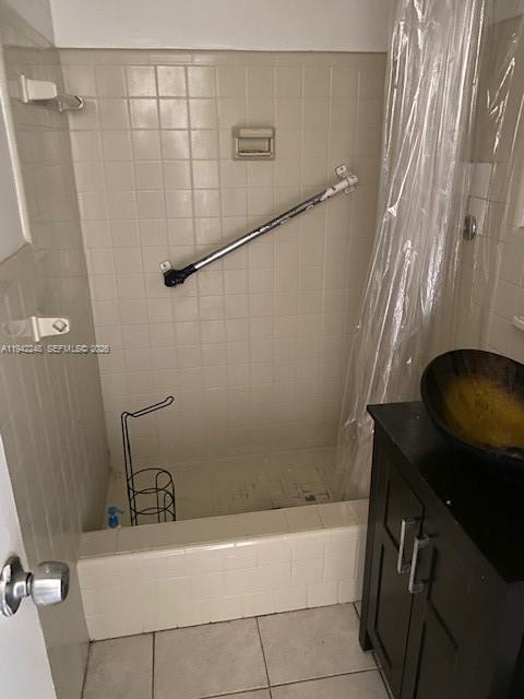A bathroom features a tiled shower-tub combination with a grab bar and a dark vanity — 100 SE 3 Ave # 3, Hallandale Beach FL 33009, HALLANDALE BEACH, FL
