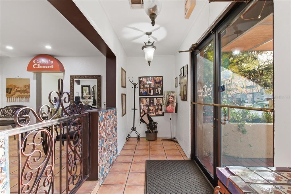 An entryway features tiled floors, a decorative metal railing, and a glass door to outside — 9729 N ARMENIA AVENUE, TAMPA, FL