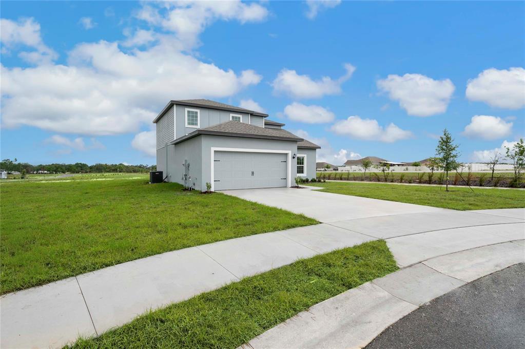A two-story house with a gray exterior and a two-car garage sits on a lot — 823 PONKAN COURT, BABSON PARK, FL