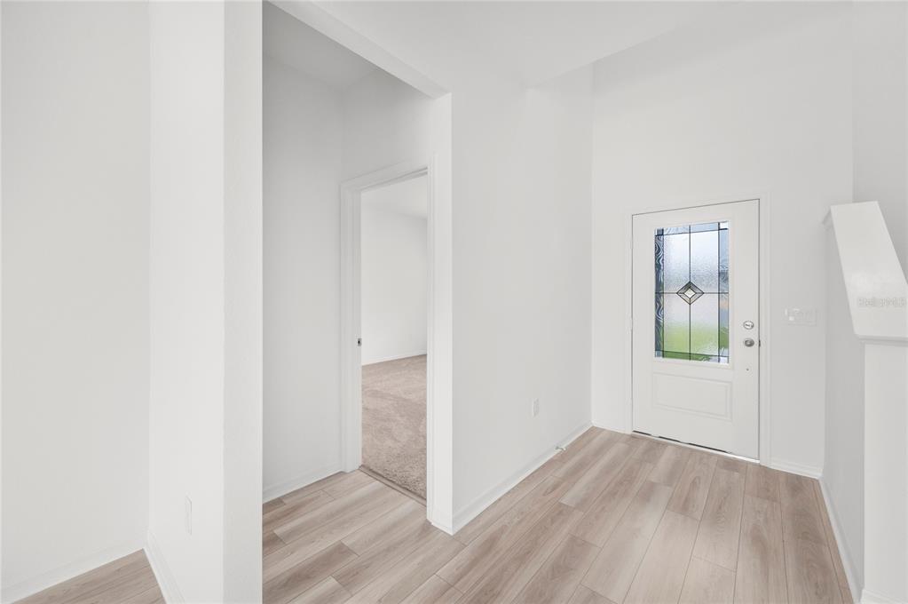 An entryway with light wood-look flooring, white walls, and a white front door with glass — 823 PONKAN COURT, BABSON PARK, FL