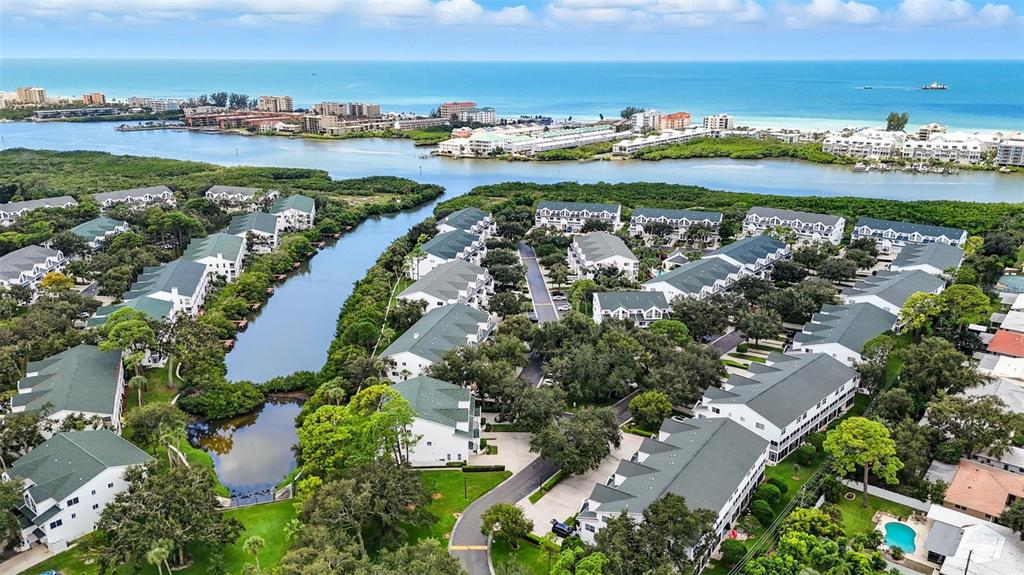 An aerial view shows a residential complex with white buildings and green roofs near water — 14837 SEMINOLE TRAIL, SEMINOLE, FL
